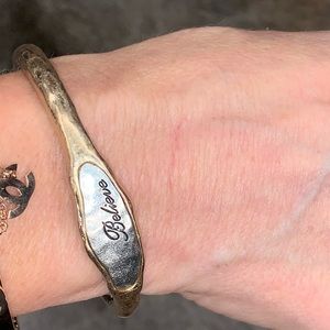 Gold bracelet w/itch silver inlay. “Believe”.